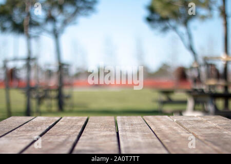 Empty table covered with sackcloth over blurred trees with bokeh background Stock Photo
