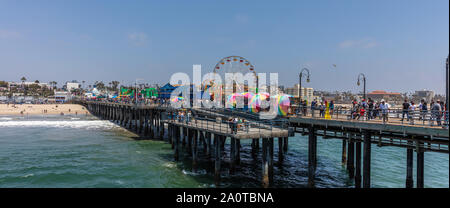 Santa Monica, Los Angeles California USA. May 30, 2019. Roller coaster and ferris wheel on Santa Monica pier, panoramic view, blue sky and sea, sunny Stock Photo