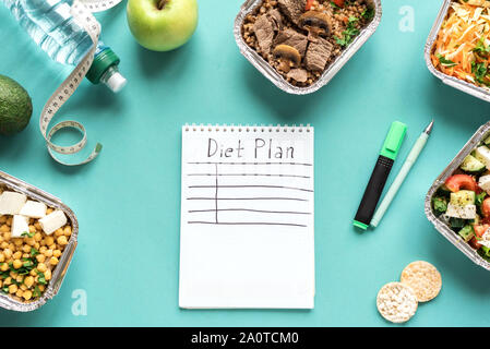 Diet plan flat lay with water, fruits, healthy meals and measuring tape. Fitness nutrition, delivery food, diet concept on blue, top view, copy space. Stock Photo