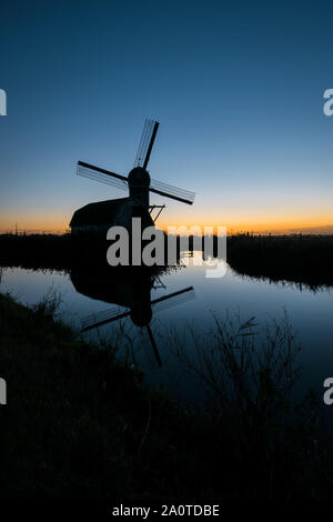 Silhouette of a dutch windmill against the twilight sky Stock Photo