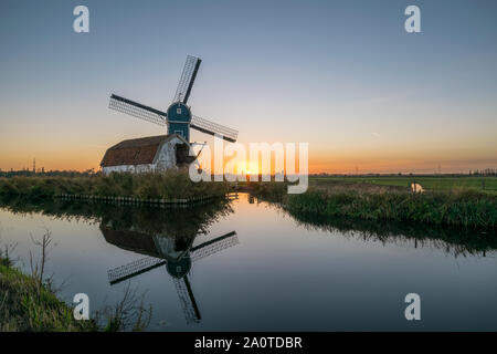 Windmill and decayed house in dutch countryside near Leiden, Holland at sunset Stock Photo