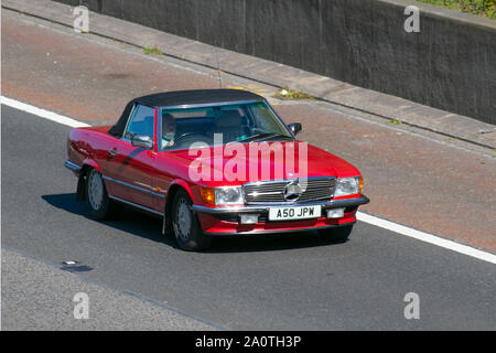1987 80s eighties red Mercedes 300 SL Auto Cabriolet T; 80s sports cars, convertible, convertibles, soft-top, open-topped, roadster, cabriolets, drop-tops south-bound on the 3 lane M6 motorway highway. Stock Photo