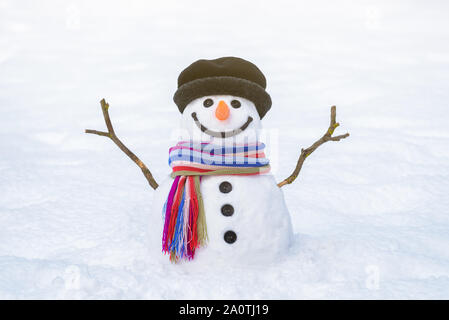 Christmas card. Funny snowman with a bright striped scarf on a background of white snow Stock Photo