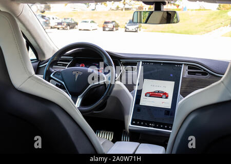 Inside of Tesla Model S seen through front-seats with information on high-tech digital dashboards. Stock Photo