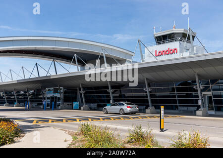 London International Airport drop-off area at the terminal with the Air Traffic Control Tower above. Stock Photo
