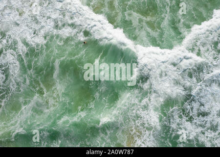 Straight down shot of man swimming in breaking waves with wite water everywhere. Straight down shot of man swimming in breaking waves with wite water everywhere.