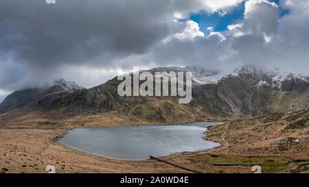 Stunning dramatic Winter landscape image of Llyn Idwal and snowcapped Glyders Mountain Range in Snowdonia Stock Photo