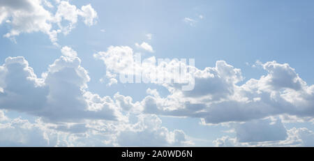 Blue sky on a sunny day. Soft texture of fluffy clouds. Concept for airy light dreams and travel. Stock Photo