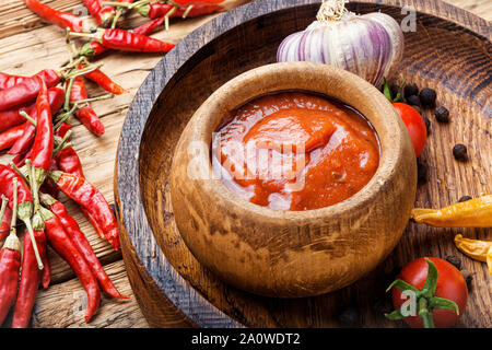 Chili peppers and chili sauce.Hot sauce from chilli peppers and tomatoes Stock Photo