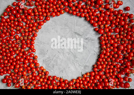 Round frame of cherry tomatoes on a gray background. Flat lay. Copy space. Stock Photo