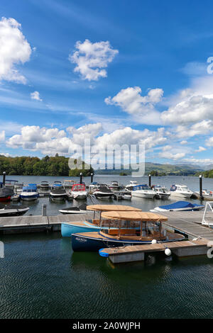 Boats moored on Lake Windermere in Cumbria's Lake District National Park on a beautiful summers day in June 2019 Stock Photo