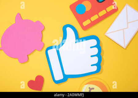 top view of colorful paper icons scattered on yellow background Stock Photo