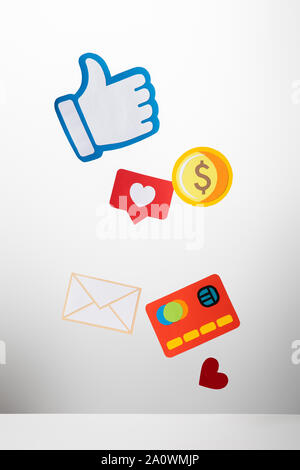 colorful paper cut with envelope, coin, credit card, hearts and thumb up on white background Stock Photo
