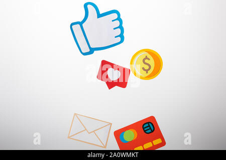 paper cut with envelope, coin, credit card, hearts and thumb up on white background Stock Photo