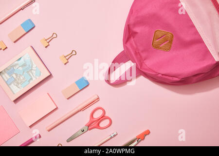 flat lay with pink school supplies and backpack isolated on pink