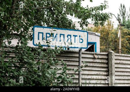 PRIPYAT, UKRAINE - AUGUST 15, 2019: sign with pripyat lettering near trees and fence Stock Photo