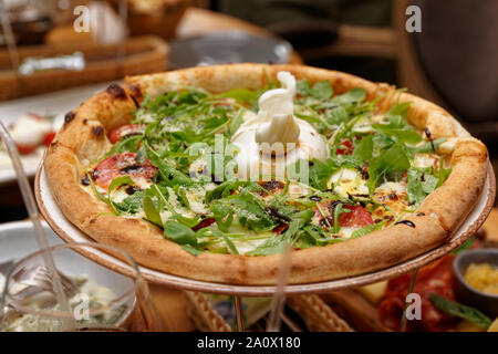 Pizza with rocket salad and fresh burrata cheese Stock Photo