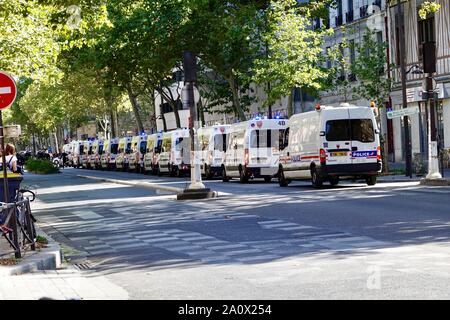 Police vans and police officers lined up on boulevard in the 12th arrondissement, preparing to manage crowds at Paris youth climate march, France. Stock Photo