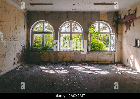 Old abandoned classroom with three big windows Stock Photo