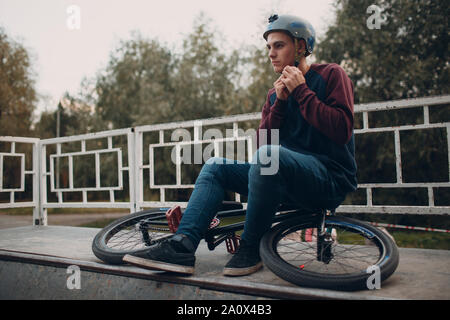 Professional young sports man cyclist with bmx bike at skatepark Stock Photo