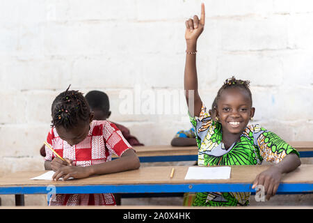 African School Children Raising Their Hands during Lesson Stock Photo