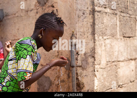 Candid Photograph of African Black Beautiful Girl drinking Freshwater Stock Photo