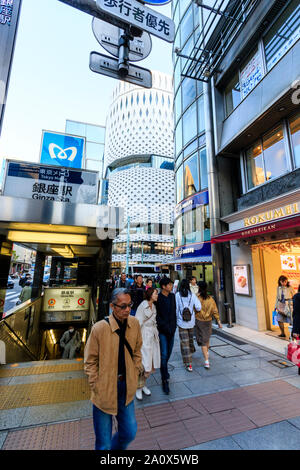 Tokyo, Ginza. People coming out of the Ginza metro station exit next to Le Cafe Douttor, while in background is the Ginza Place white building. Daytim Stock Photo