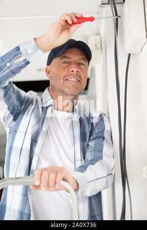 installing an electrical outlet in to the white wall box Stock Photo