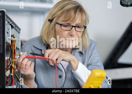 female technician using voltage meter Stock Photo