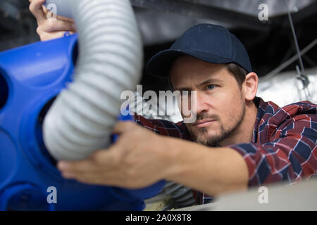 male electrician installing ventilation in ceiling Stock Photo