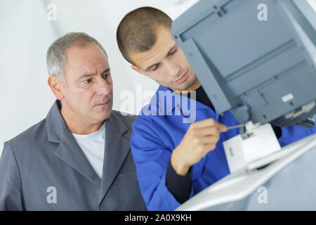 young apprentice fixing cartridge in photocopy machine Stock Photo