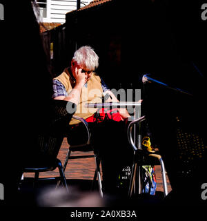 Poorly Sighted Or Blind Man Sitting Alone on a Wicker Chair Waiting and Thinking Stock Photo