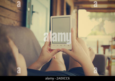 Caucasian woman reading ebook on couch. Copy space. Selective focus on hands and book. Stock Photo