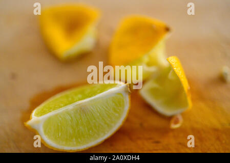 Lemon Ripe Limes Cut Up and Squeezed on Wooden Chopping Board Stock Photo