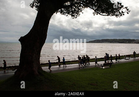 Swansea, Wales, UK. 22nd Sept 2019. Competitors taking part in the Admiral Swansea Bay 10k race along the seaffront at West Cross near Swansea today under stormy skies during a break in the wet weather. Credit: Phil Rees/Alamy Live News Stock Photo