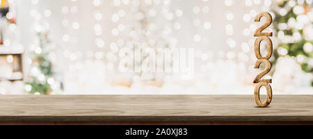 happy new year 2020 at woooden table top with abstract warm living room decor with christmas tree string light blur background with snow,Holiday backd Stock Photo