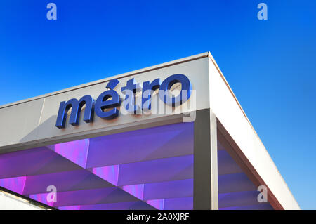 Metro station entrance ornated by purple and pink leds, projecting the dark underground transport in the blue sky Stock Photo