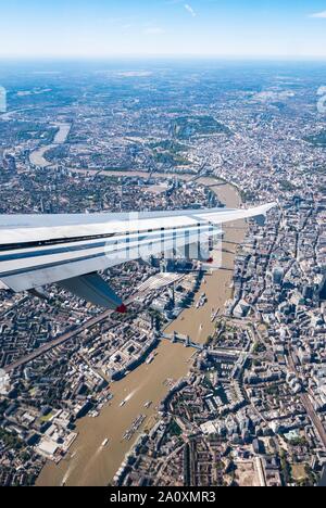 View from plane window with wing over Thames River, Tower Bridge, Hyde Park & City of London, England, UK Stock Photo