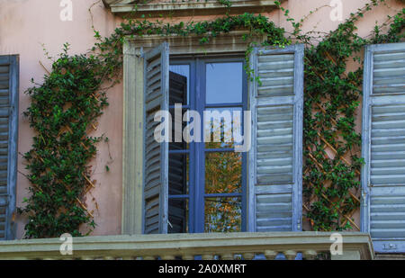 lights and autumn colors reflected in the window of a period villa Stock Photo