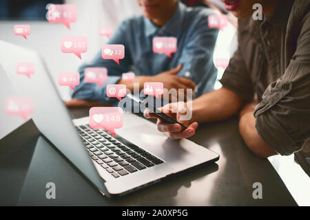 Friends receive messages, hearts, email from social network in the laptop and smartphone Stock Photo