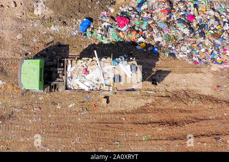 Loaded Garbage Trucks unloading at a Municipal landfill, Top down aerial Stock Photo