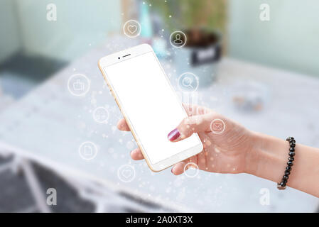 Phone in woman hand surrounded with social network icons. Isolated screen for mockup. Stock Photo