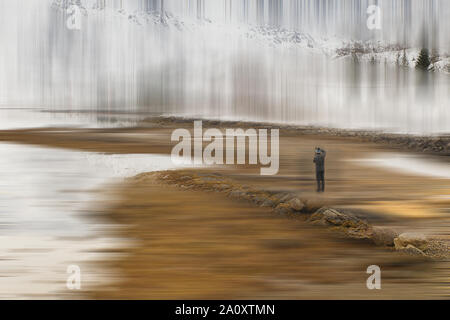 man photographing icy landscape in lofoten islands , norway Stock Photo