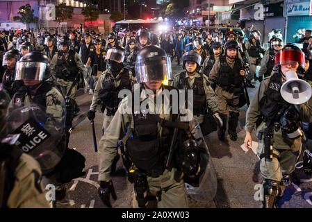 Riot police officers patrol streets during the protest.One more weekend, protesters set up barricade on fire, burned a Chinese flag and police fired pepper spray in renewed clashes over grievances by the anti-government demonstrators. Stock Photo