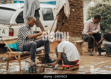 BAHIR DAR, ETHIOPIA, APRIL 21th. 2019, Traditional shoe cleaner on the street of Bahir Dar during easter holiday. April 21th. 2019, Bahir Dar, Ethiopi Stock Photo