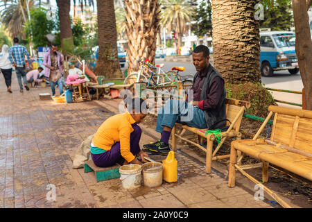 BAHIR DAR, ETHIOPIA, APRIL 21th. 2019, Traditional woman shoe cleaner on the street of Bahir Dar during easter holiday. April 21th. 2019, Bahir Dar, E Stock Photo