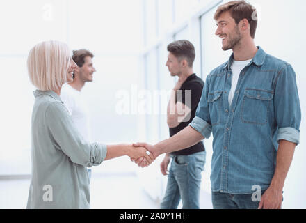 coworkers shaking hands in the office lobby. Stock Photo