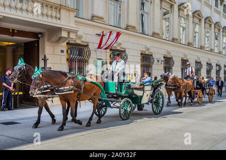 Horse-drawn carriages (fiakers) carrying tourists along the Herrengasse, Vienna, Austria. Stock Photo