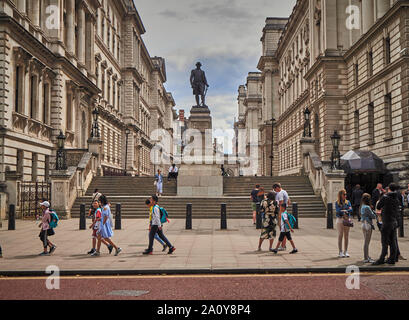 People walking by the entrance to the Churchill Wars Rooms at Clive Steps, King Charles Street, London with a statue of Clive of India (Robert Clive) Stock Photo