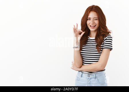 Cheeky playful redhead female in striped t-shirt wink suggestive
